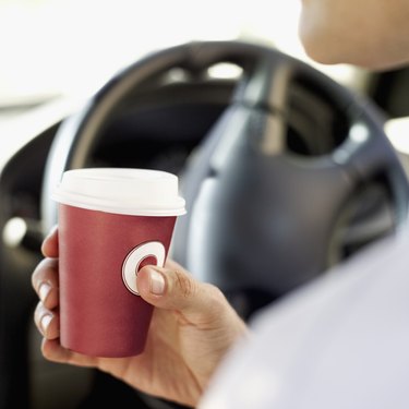 man holding a cup in a car