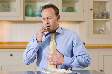 Man taking indigestion tablet