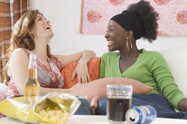 Two women laughing on sofa