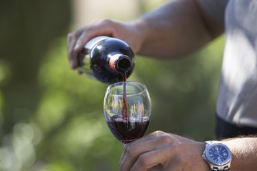 Man pouring wine, close-up of glass