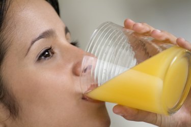 Side view of a young woman drinking juice