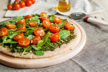 Pizza with pesto, spinach and cherry tomatoes