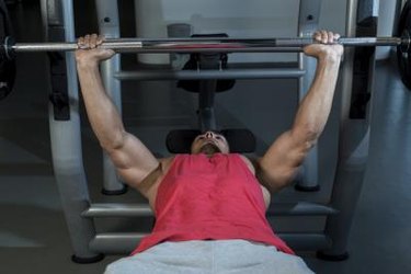 Young Men In Gym Exercising On The Bench Press