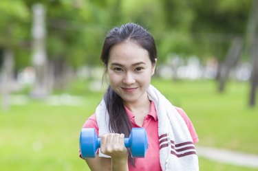 Fitness woman lifting dumbbell weight training outside