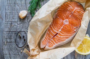 Salmon steak with pepper, dill, lemon, garlic on baking paper