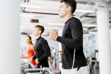 Group of young people using treadmills in a gym