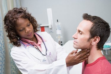 Doctor examining glands of throat of patient