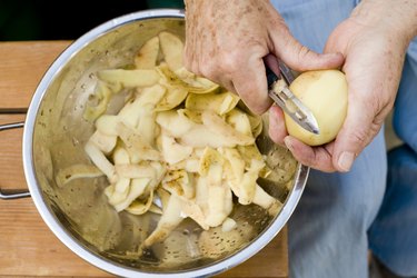 Person's hands peeling potatoes