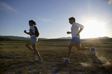 Man and woman running at sunset, California, USA
