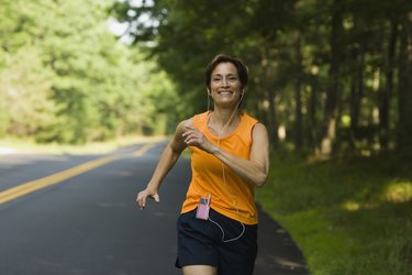 微笑的女人沿着路慢跑