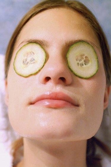 Close-up of a mid adult woman with cucumber slices on her eyes