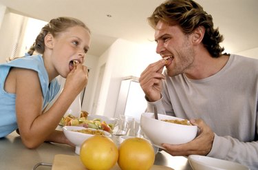 Father and daughter eating cereal