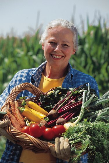 Mature woman holding a basket of fresh vegetables