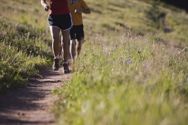 People running along path on hillside