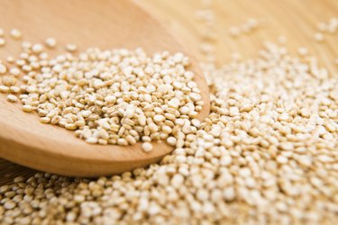 a close up of a wooden spoon in a bowl of quinoa