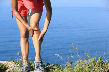 young sporty woman hold her sports injured leg