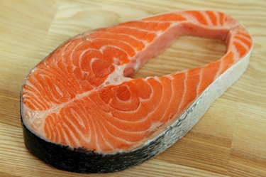 Close-up salmon steak on wooden plate