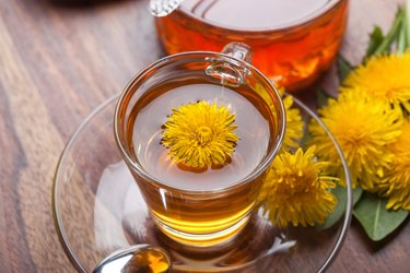 herbal tea of dandelion with honey, blossoms on wooden table