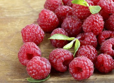 Red ripe raspberries on a wooden background