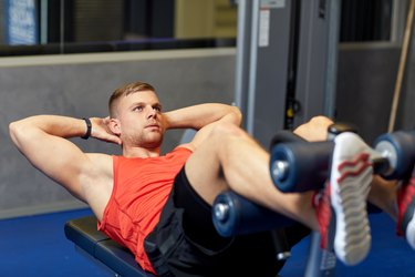 young man making abdominal exercises in gym