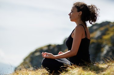 Woman practicing yoga on mountain