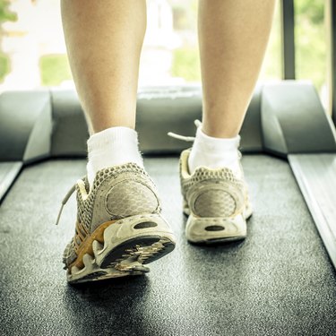 woman's muscular legs on treadmill