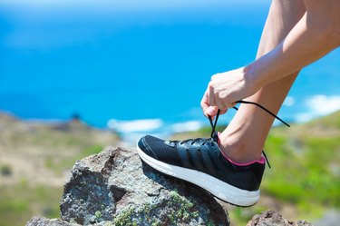 Female hiker tying her shoes