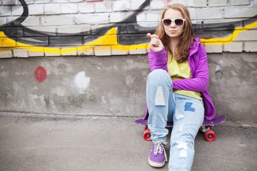 Blond teenage girl with lollipop, urban portrait