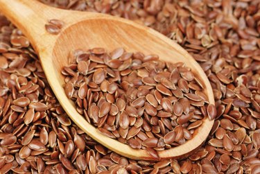 close up of flax seeds and wooden spoon food background