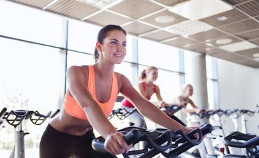 group of women riding on exercise bike in gym