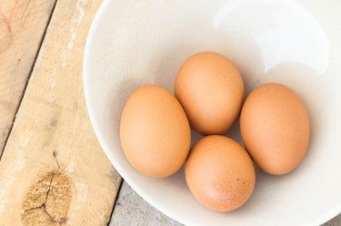 chicken eggs on towel and bowl