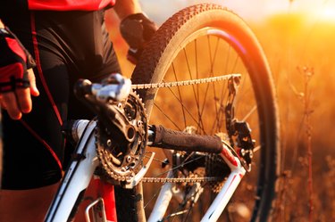 Young man repairing mountain bike in the forest