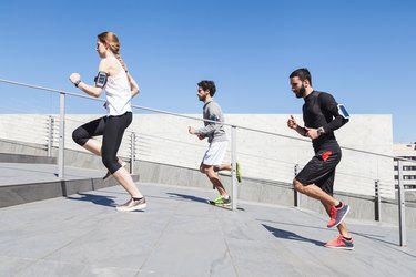 Three young friends running on the steps of a building