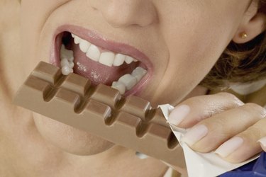 Extreme close-up of mid adult woman eating a chocolate candy bar