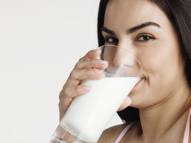 Young woman drinking milk, smiling, portrait, close-up