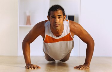 Portrait of a young man doing push ups on the floor