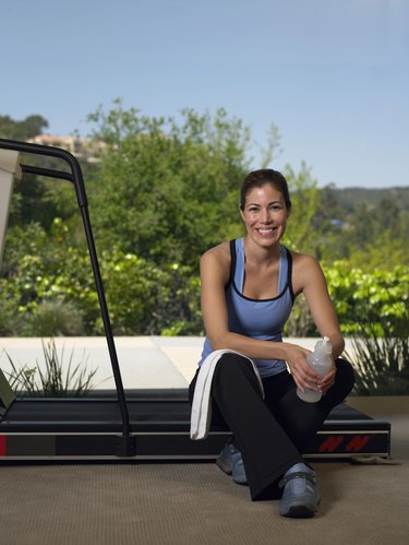 Woman sitting on treadmill