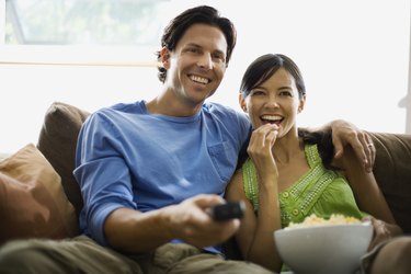 Couple on sofa eating popcorn