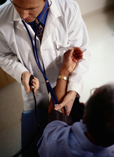 Doctor checking blood pressure of male patient, elevated view