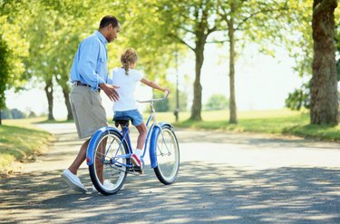 Father Helping His Daughter Ride a Bicycle