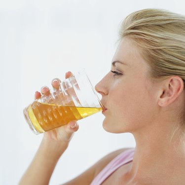 side profile of a young woman drinking a glass of juice