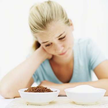 teenage girl looking at two bowls of white and brown sugar