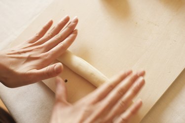 Woman making bagels, rolling dough, close up, blurred motion