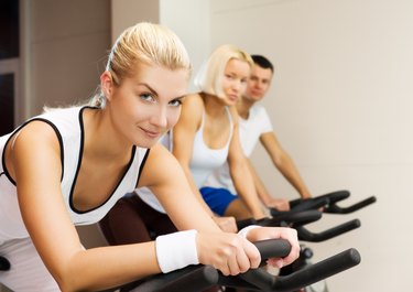 Group of people doing exercise on a bike in a gym