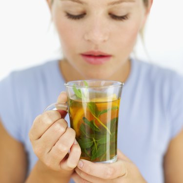 close-up of a young woman holding a cup of herbal tea