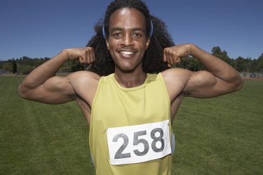 Male track athlete flexing biceps