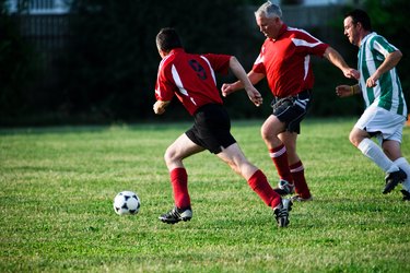 Soccer players chasing ball in game