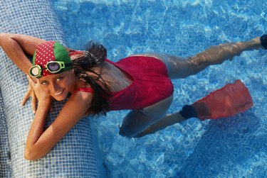 Woman in pool wearing swim cap