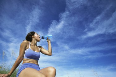 Low angle view of a young woman drinking water from a bottle