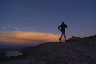 Silhouette of a man running on a hill